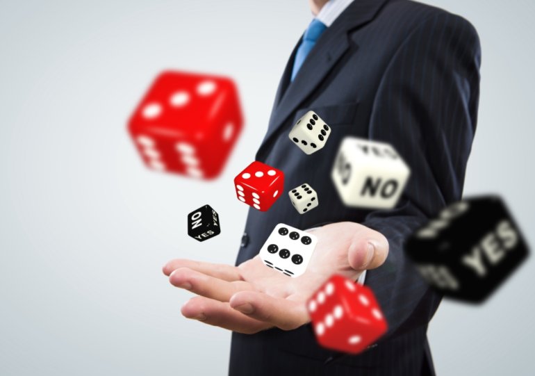 A man in a suit throws red and black dice yes no
