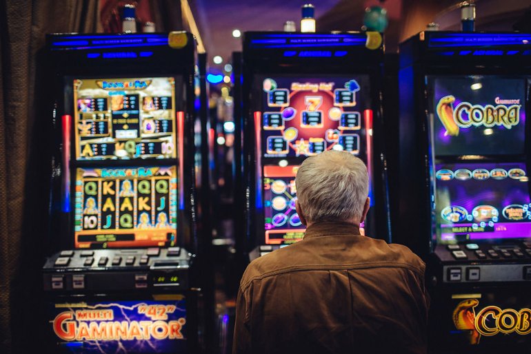 An elderly man at a slot machine