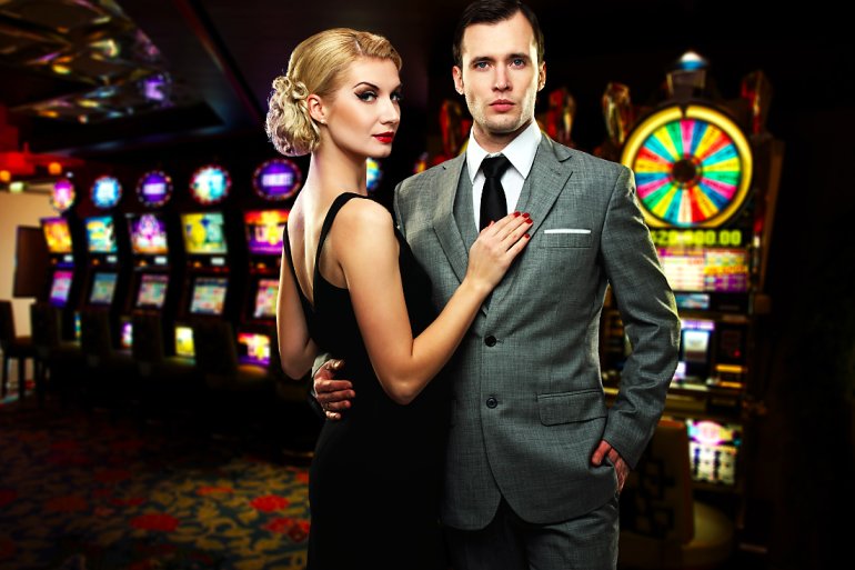 Beautiful couple in a casino at pokie machines