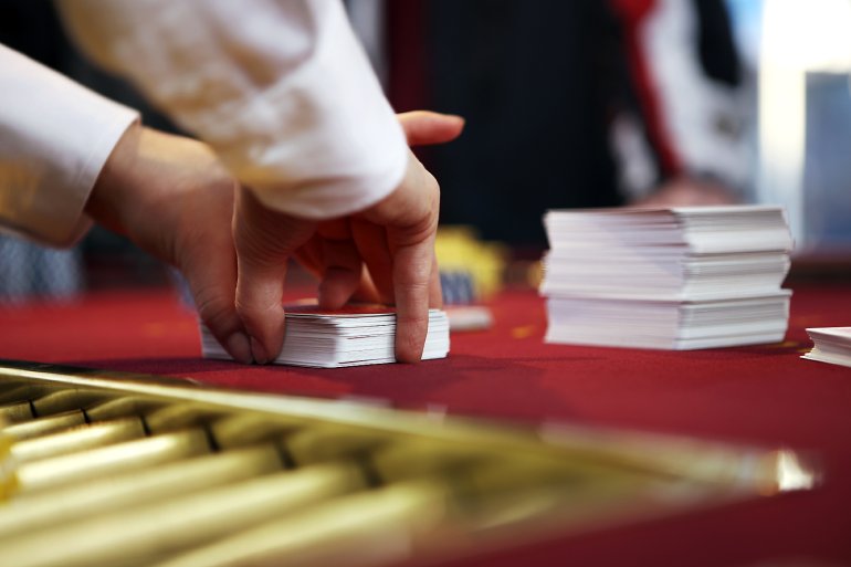 The croupier shuffles decks of cards for blackjack